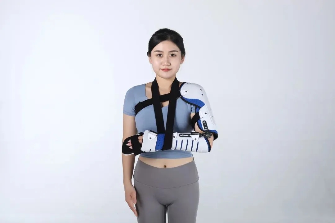 Product demonstration image: Broken Humerus Cast on a medical mannequin arm, showing the blue fabric exterior, adjustable straps, and shoulder support structure.