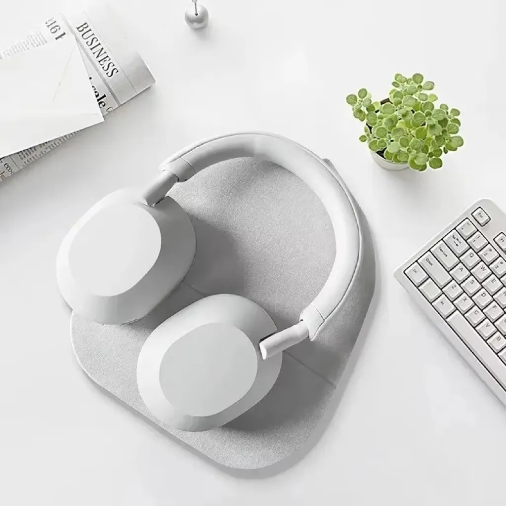 Audio devices combination: TWS earbuds like AirPods Pro 3, over-ear headphones like Sony WH-1000XM5, and Bluetooth speaker like JBL Charge 5 on a light gray matte desk.