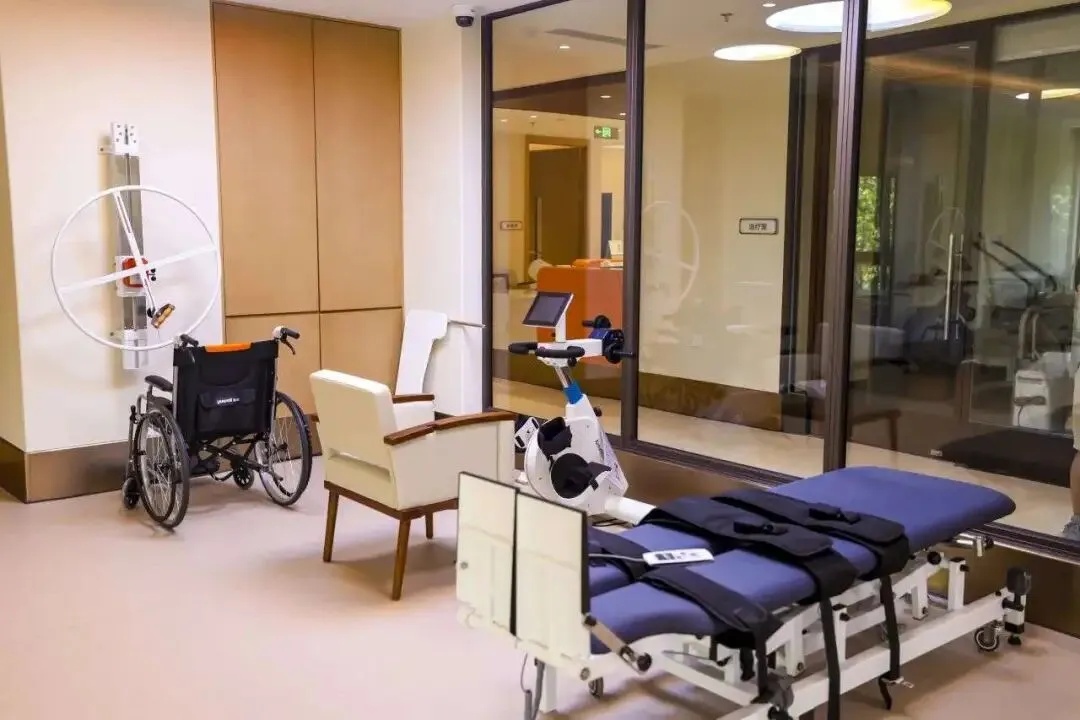 Common area in a modern nursing home, featuring an electric Manual Or Electric Lift Transfer Chair. A resident is being comfortably transferred to an armchair by a caregiver using a remote control.